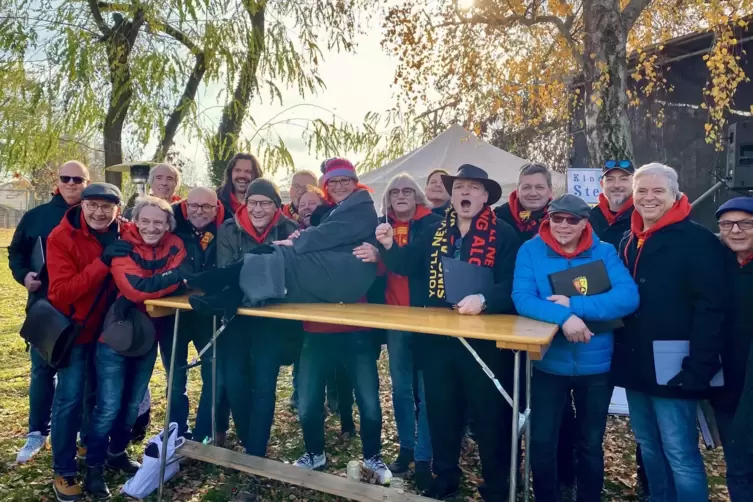Bei seinem Gastauftritt in Eppstein nehmen die Sänger Benefiz-Adventsmarkt-Organisatorin Mery Mappes in ihre Mitte. Foto: Andreas Lang